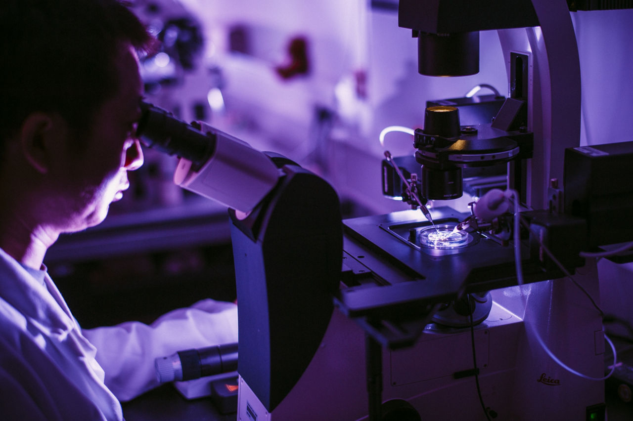 Scientist looking into microscope